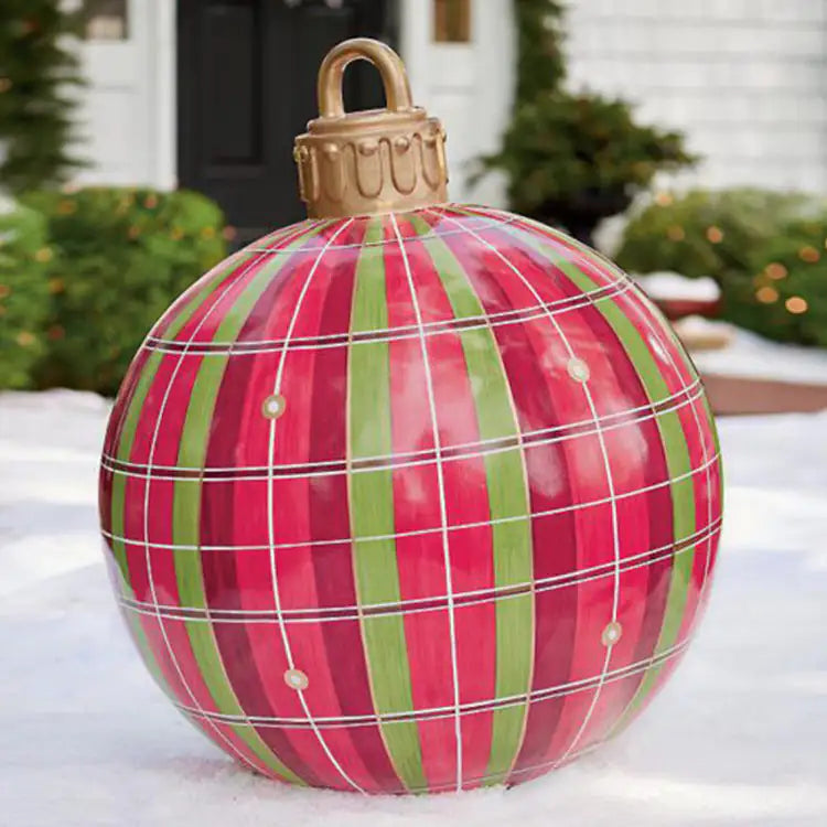 Large red and green plaid Christmas ornament on a snowy surface