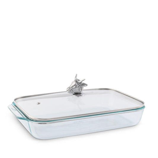 Clear glass baking dish with silver rim and handle on a white background