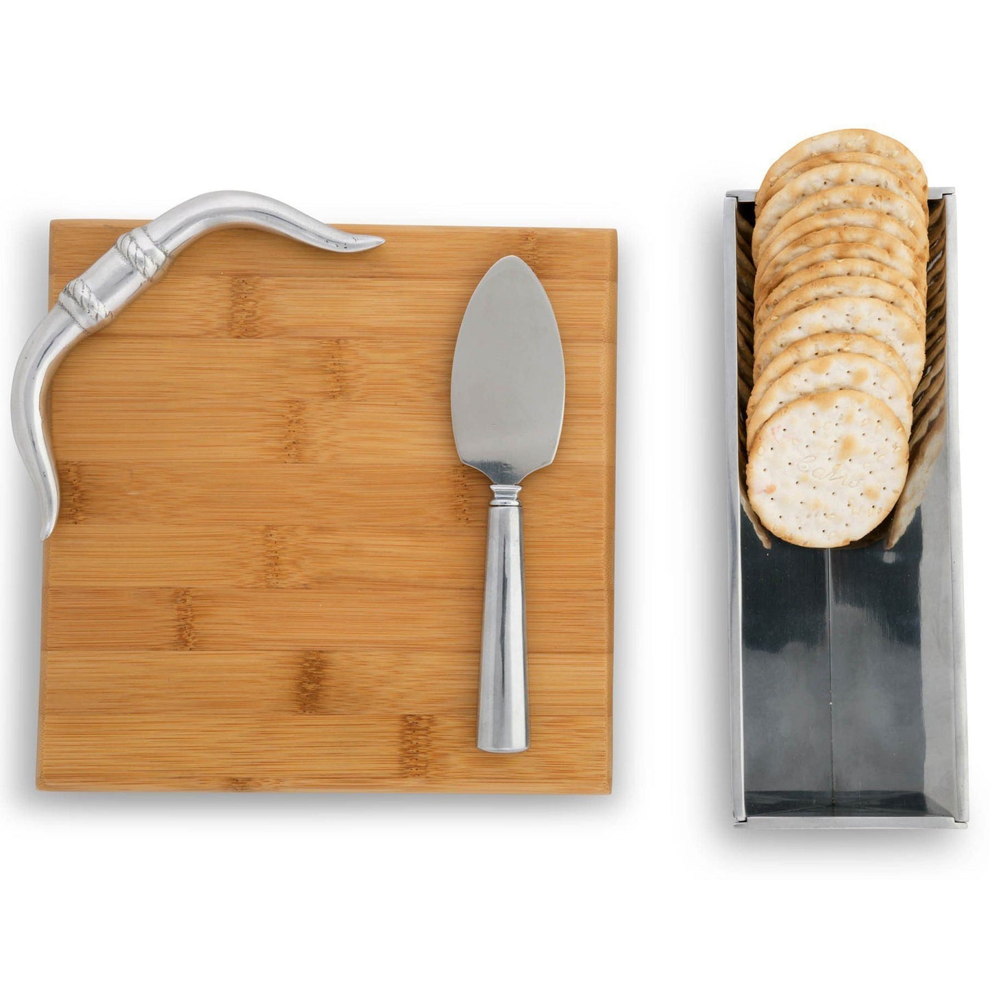 Bamboo cutting board with knife, cheese spreader, and a container of crackers on a white background