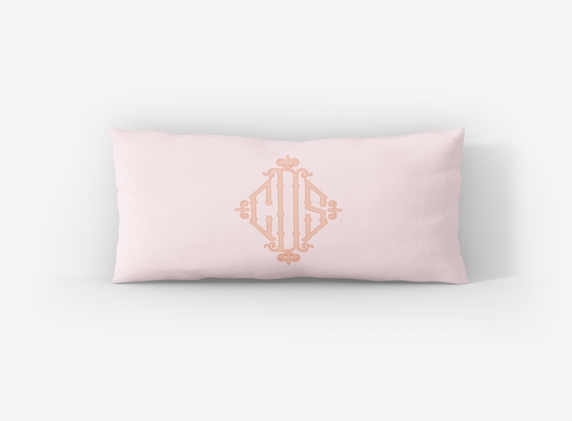 Pink pillow with gold monogram on a white background